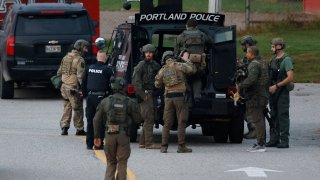 Law enforcement officials load into a tactical vehicle at Lisbon High School in Lisbon, Maine, Oct. 26, 2023, as a manhunt resumes for the suspect in a mass shooting in nearby Lewiston the previous day.