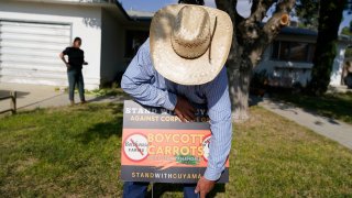 Jake Furstenfeld, a cattle rancher, places a sign outside a house, Wednesday, Sept. 20, 2023, in New Cuyama, Calif. Furstenfeld is among the leaders of the carrot boycott being encouraged in the Cuyama Valley as a results of a water rights dispute with carrot producers Grimmway and Bolthouse. (AP Photo/Marcio Jose Sanchez)