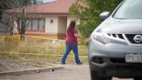 FILE - An onlooker walks along the police line outside Return to Nature Funeral Home facility in Penrose, Colo.