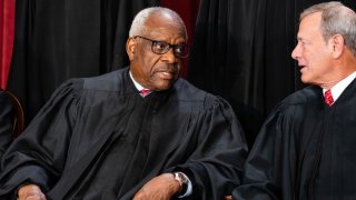 Associate Justice Clarence Thomas, left, talks to Chief Justice John Roberts during the formal group photograph at the Supreme Court in Washington, DC, US, on Friday, Oct. 7, 2022. 