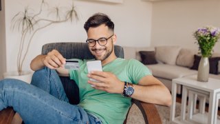 Young man relaxing and shopping online at home.