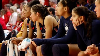 UConn players watch a college basketball game