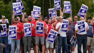 United Auto Workers members hold picket signs