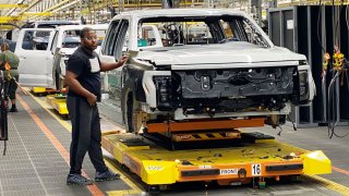 Ford workers produce the electric F-150 Lightning pickup at the automaker’s Ford Rouge Electric Vehicle Center on Dec. 13, 2022.