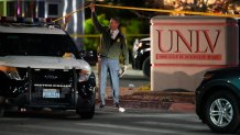 A police officer walks under crime scene tape in the aftermath of a shooting at the University of Nevada, Las Vegas.