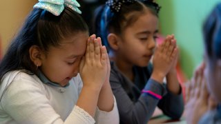 Gaby Meza Rodriguez, 7, left, prays with other children during a Sunday school session while her parents attend a church service, Sunday, Dec. 17, 2023, in Fort Morgan, Colo.