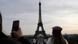 Tourists watch the Eiffel Tower