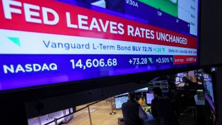 Traders react as a screen displays the Fed rate announcement on the floor of the New York Stock Exchange (NYSE) in New York City, U.S., December 13, 2023. REUTERS/Brendan McDermid