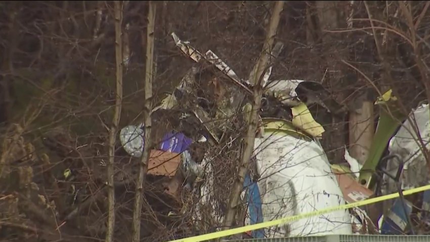 The wreck of a crashed small plane behind a home in Londonderry, New Hampshire, on Friday, Jan. 26, 2025.