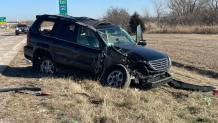 The mangled wreckage or the black SUV after the crash.