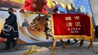 A man leads a bull during a ceremony celebrating the New Year’s opening of the South Korea stock market at the Korea Exchange in Seoul on January 2, 2023.