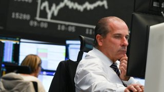 A stock trader looks at his monitors in the trading room of the Frankfurt Stock Exchange. Worries about a new coronavirus mutation in southern Africa have dealt a major blow to the German stock market. 