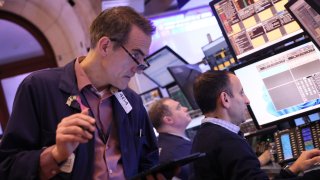 Traders work on the floor of the New York Stock Exchange during morning trading on Feb. 14, 2024.