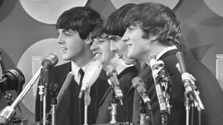 FILE - The Beatles address the media in the press room of Kennedy International Airport on their arrival, Feb. 7, 1964, in New York.