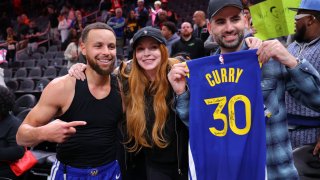 Stephen Curry #30 of the Golden State Warriors poses with actress Lindsay Lohan and her husband Bader Shammas