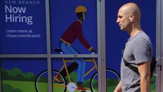 A pedestrian passes a “Now Hiring” sign at a Chase Bank branch in Somerville, Massachusetts, U.S., September 1, 2022. 