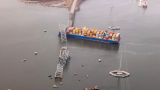In an aerial view, cargo ship Dali is seen after running into and collapsing the Francis Scott Key Bridge on March 26, 2024 in Baltimore, Maryland.