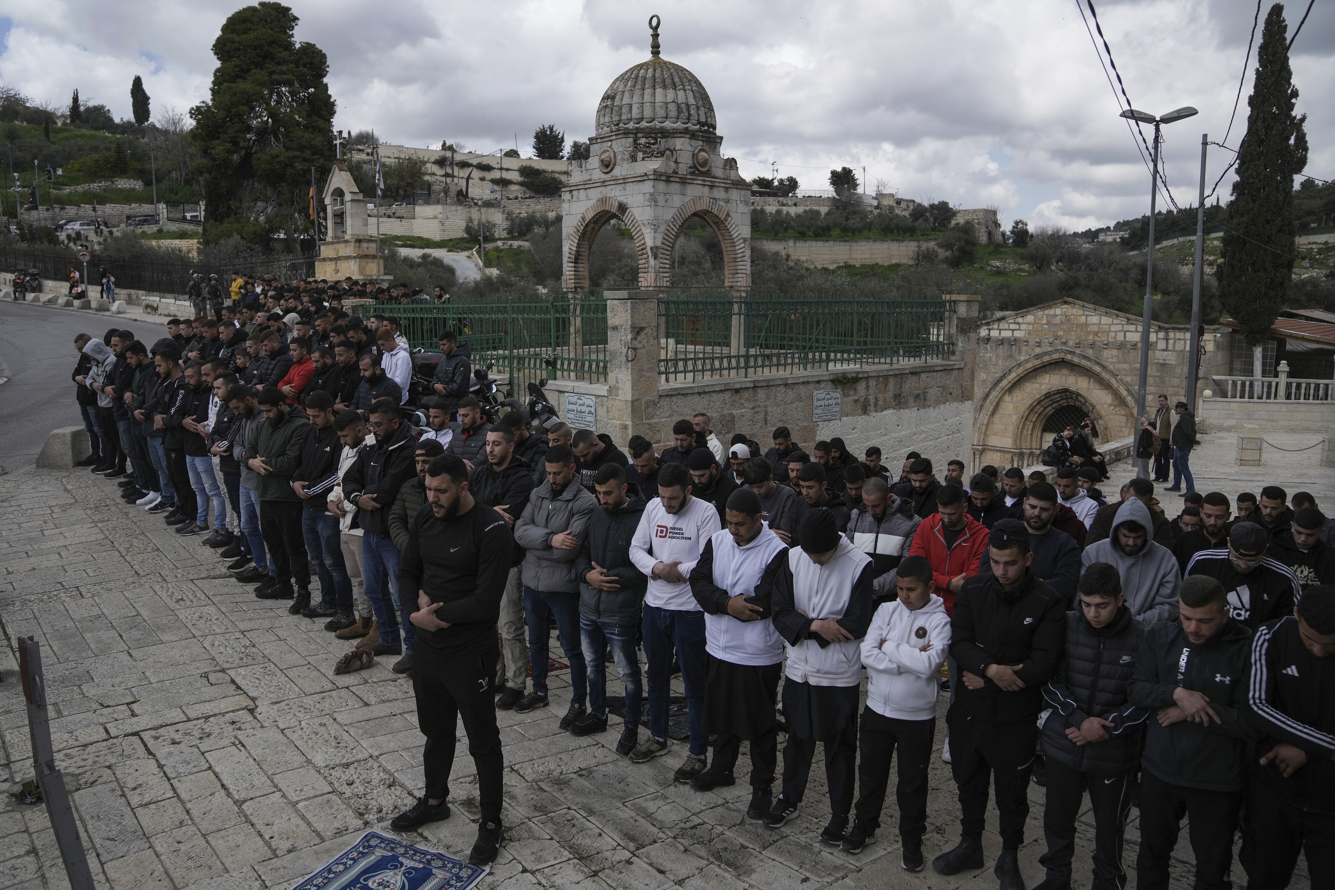 Palestinian Muslim worshipers who were prevented from entering the Al-Aqsa Mosque compound, pray outside Jerusalem's Old City, Friday, March 8, 2024. Restrictions put in place amid the Israel-Hamas war have left many Palestinians concerned they might not be able to pray at the mosque, which is revered by Muslims. (AP Photo/Mahmoud Illean)