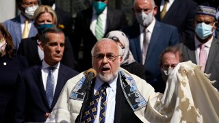 FILE- Rabbi Abraham Cooper, center, of the Simon Wiesenthal Center, speaks in front of civic and faith leaders outside City Hall, Thursday, May 20, 2021, in Los Angeles. A U.S. Congress-mandated group cut short a fact-finding mission to Saudi Arabia over officials in the kingdom ordering a Jewish rabbi to remove his kippah in public, highlighting the religious tensions still present in the wider Middle East. (AP Photo/Marcio Jose Sanchez, File)
