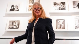 Pattie Boyd next to a set of photographs from The Pattie Boyd Collection, at Christie’s, in London, Thursday, March 14, 2024.