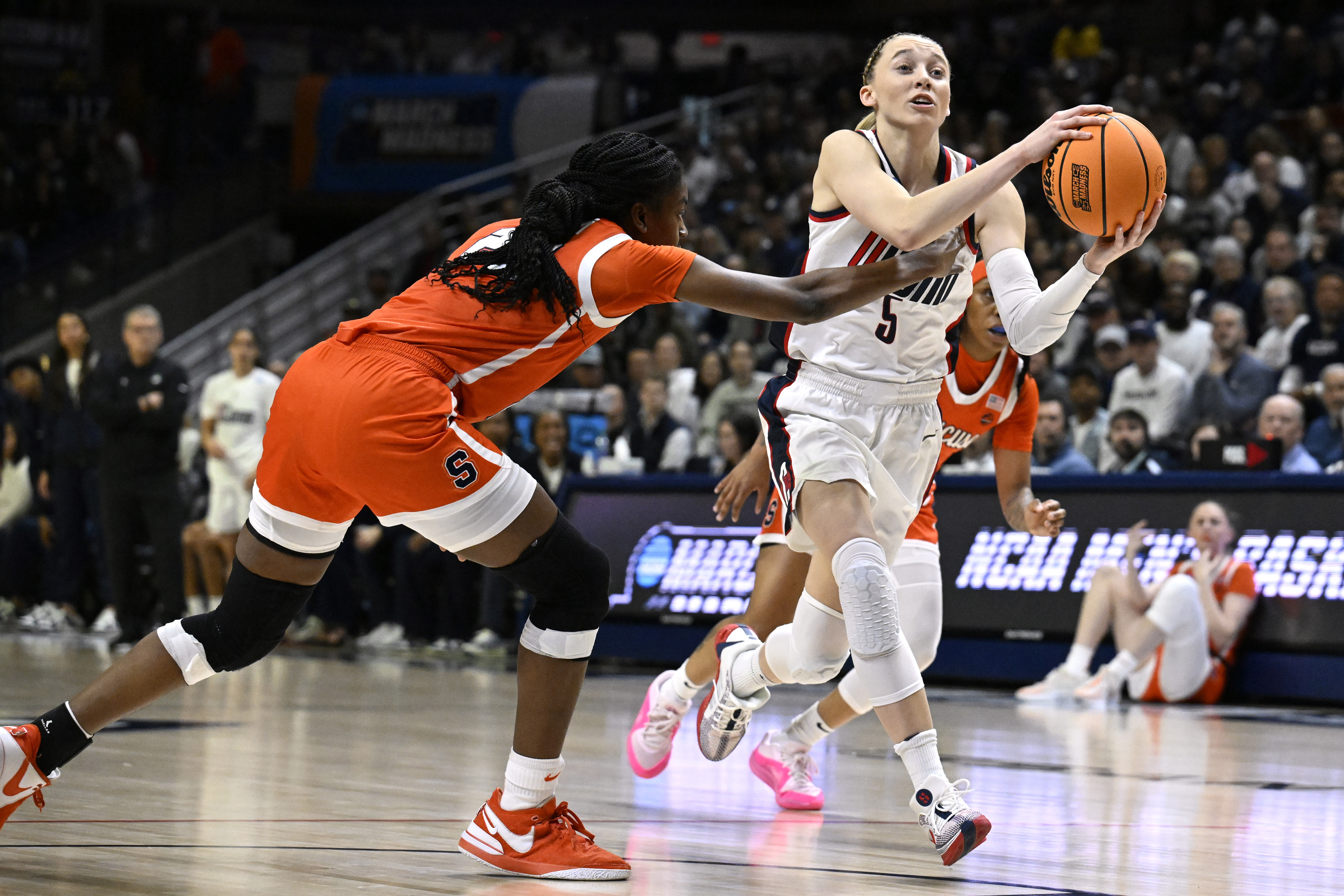 UConn guard Paige Bueckers, right, looks to pass while guarded by Syracuse forward Alyssa Latham, left, in the first half of a second-round college basketball game in the NCAA Tournament, Monday, March 25, 2024, in Storrs, Conn.