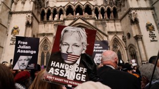 Demonstrators hold placards after Stella Assange, wife of Wikileaks founder Julian Assange, released a statement outside the Royal Courts of Justice, in London, Tuesday, March 26, 2024. Two High Court judges said they would grant Assange a new appeal unless U.S. authorities give further assurances about what will happen to him. The case has been adjourned until May 20. (AP Photo/Alberto Pezzali)
