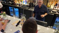 UConn's Geno Auriemma serves up drinks in Manchester Tuesday night