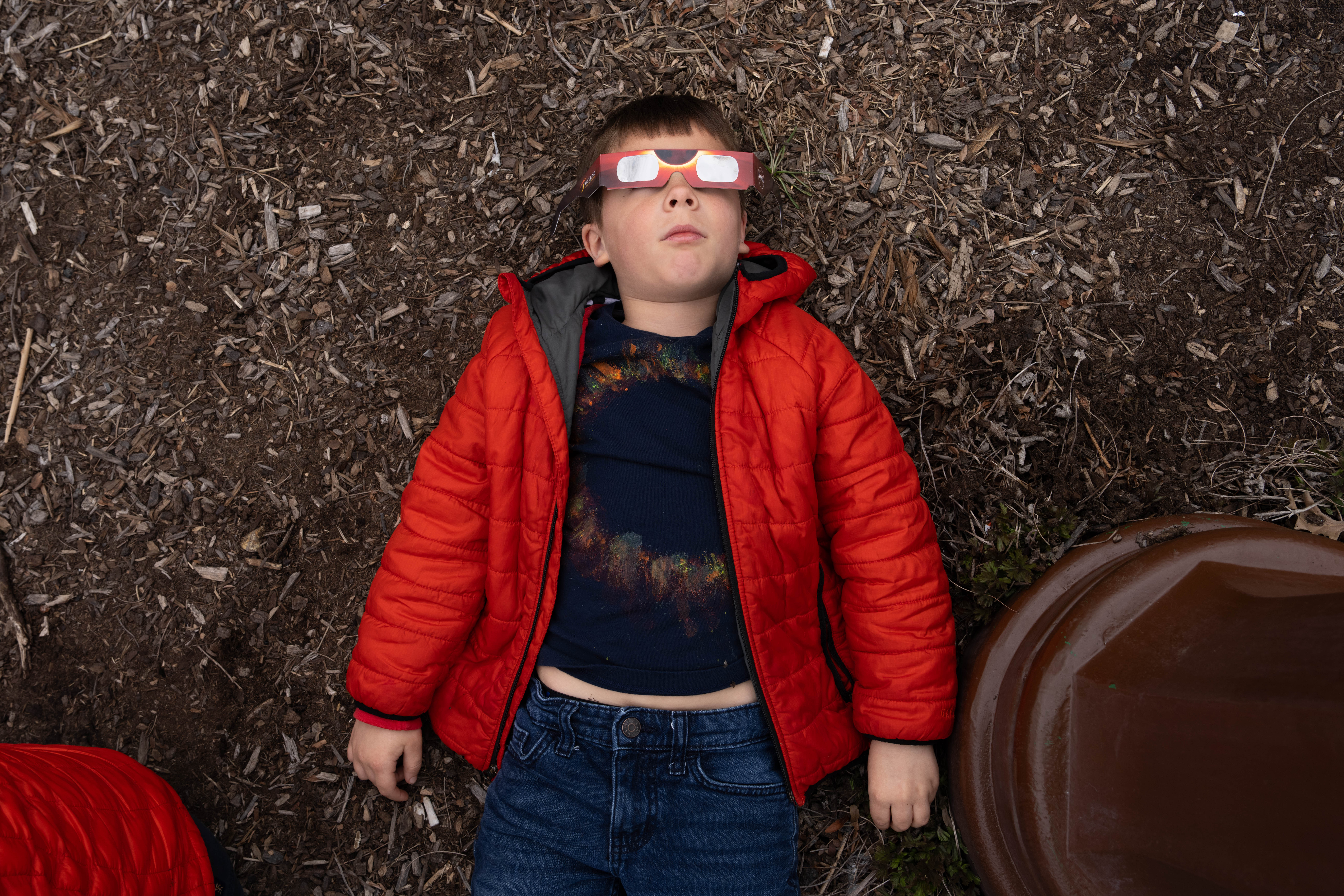 Augustus Krach, 6, looks to the sky wearing glasses before the Solar Eclipse on April 8, 2024 in Niagara Falls, New York.