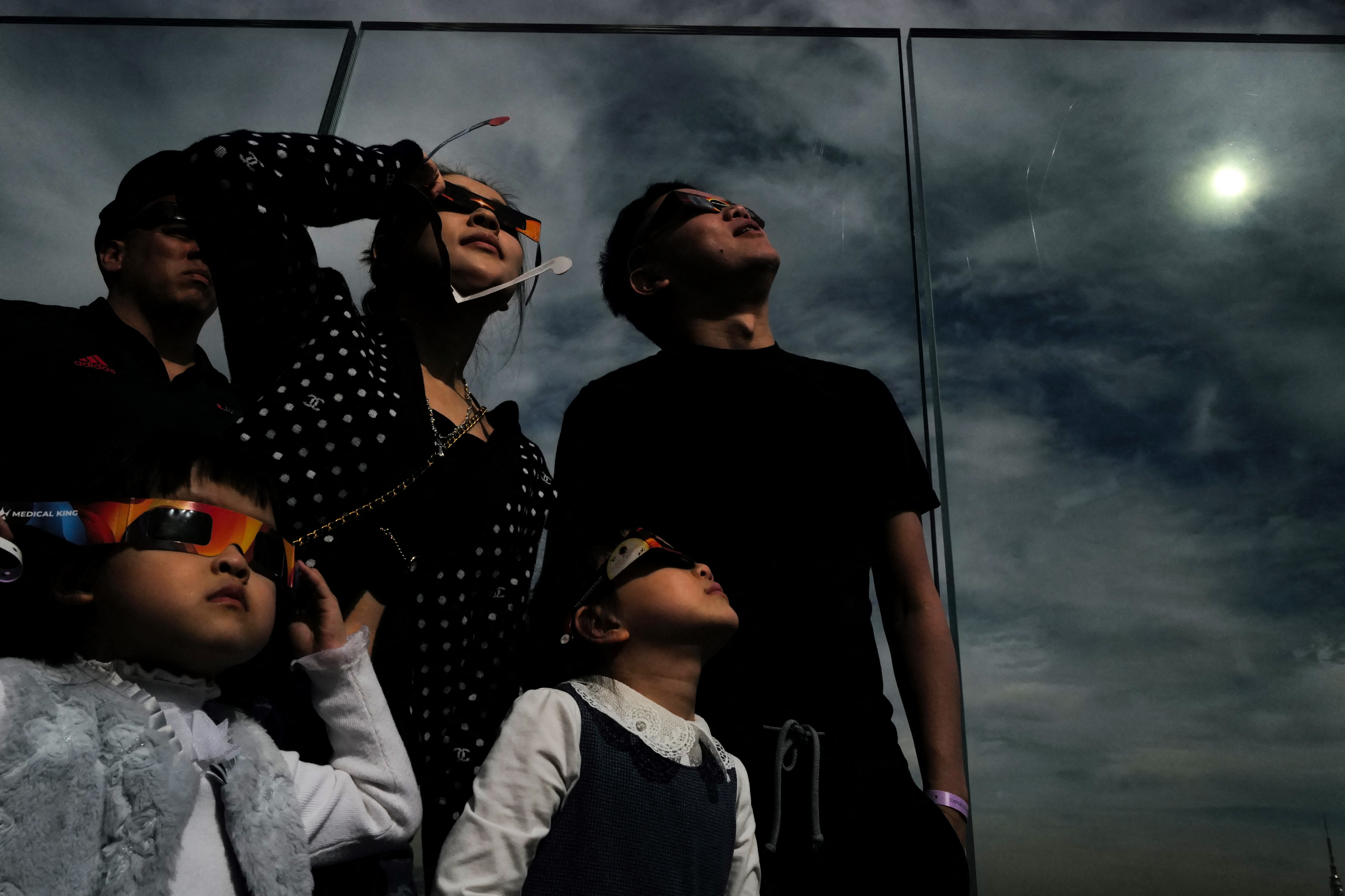 A woman looks toward the sky at the ‘Edge at Hudson Yards’ observation deck during a total solar eclipse across North America, in New York City on April 8, 2024.