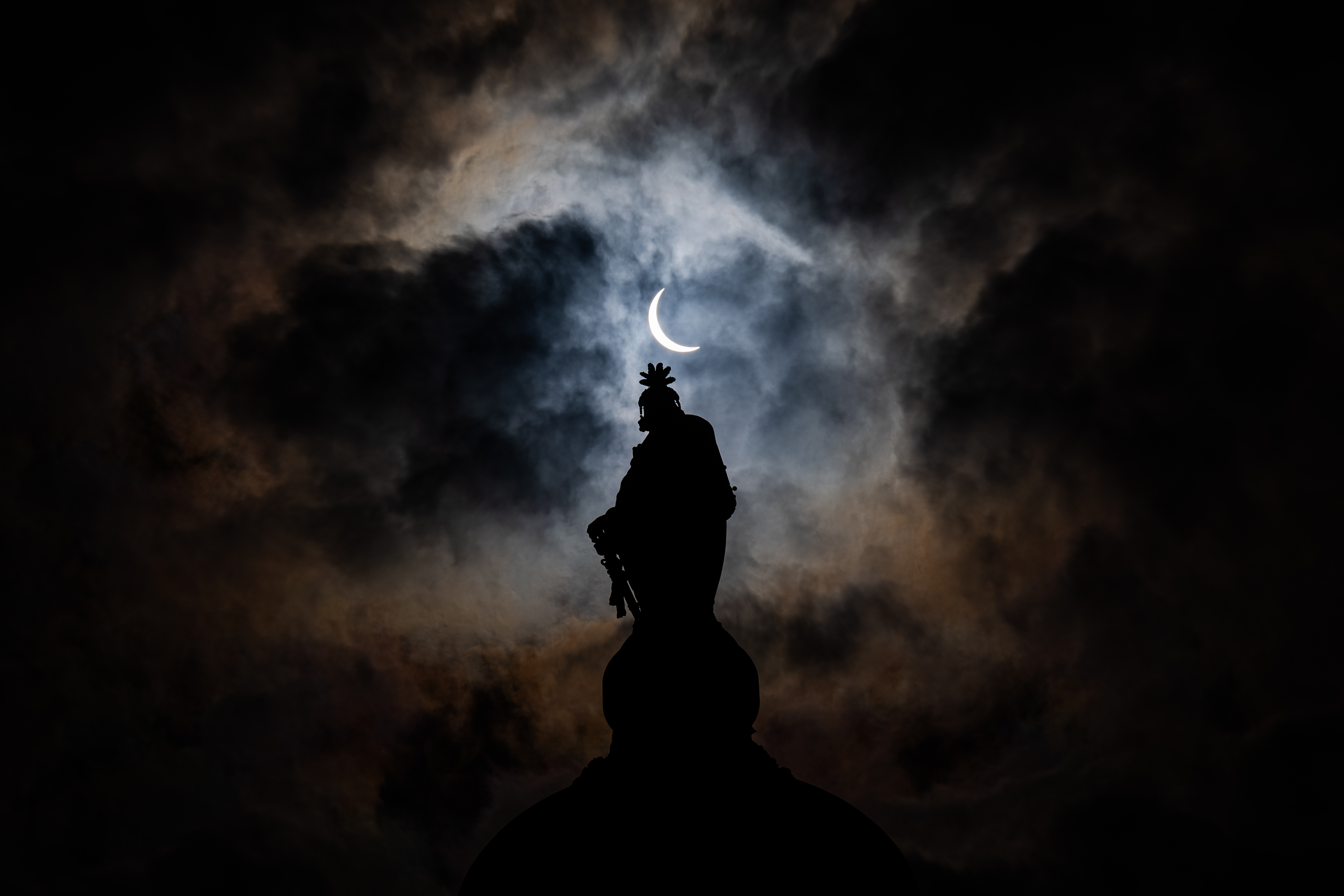 The partial solar eclipse is seen above the Statue of Freedom atop the dome of the U.S. Capitol Building on Capitol Hill on April 8, 2024 in Washington, DC.