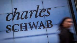 A pedestrian walks past a Charles Schwab office in New York.