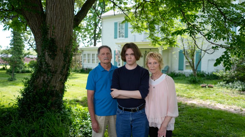 Jesse Fernandez, center, stands with his former foster parents Jason and Joyce White