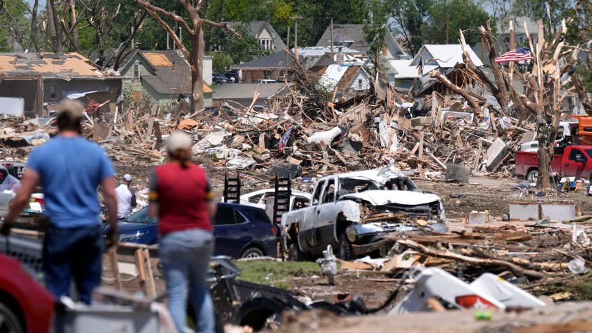 People survey a tornado damaged neighborhood, Thursday, May 23, 2024, in Greenfield.