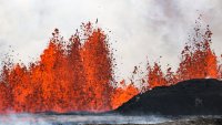 An Iceland volcano spews red streams of lava toward an evacuated town