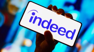 In this photo illustration, the Indeed logo is displayed on