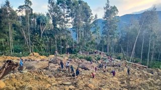 People gather at the site of a landslide in Maip Mulitaka in Papua New Guinea