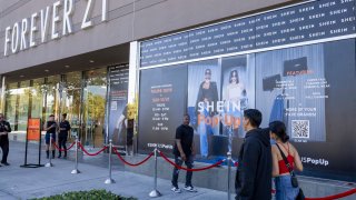 Shoppers walk past advertisements on the opening day of fast-fashion e-commerce giant Shein, which hosted a brick-and-mortar pop-up inside Forever 21 at the Ontario Mills Mall in Ontario on Oct. 19, 2023.