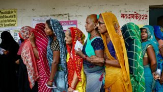 Women stand in a queue to cast their votes at a polling station in Saroi village, Bhadohi district in India’s Uttar Pradesh state on May 25, 2024, during the sixth phase of voting in India’s general election.