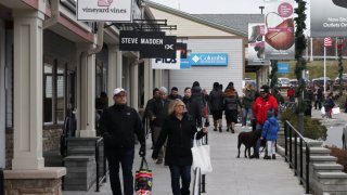 People walk past the Vineyard Vines, Steve Madden, Fila and Columbia Sportswear Company stores at the Woodbury Common Premium Outlets shopping mall on November 17, 2019 in Central Valley, New York.