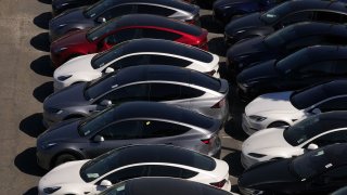 In an aerial view, brand new Tesla cars sit parked at a Tesla dealership on May 31, 2024 in Corte Madera, California.