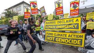 Sunrise Movement protesters gather near Vice President Kamala Harris’ Brentwood home calling on her to urge President Joe Biden to declare a climate emergency. Simon Aron, left, and Josiah Edwards, center, lead a chant.