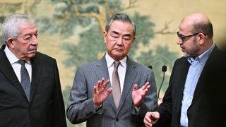 (L-R) Mahmoud al-Aloul, Vice Chairman of the Central Committee of Palestinian organisation and political party Fatah, China’s Foreign Minister Wang Yi, and Mussa Abu Marzuk, senior member of the Palestinian Islamist movement Hamas, attend an event at the Diaoyutai State Guesthouse in Beijing on July 23, 2024. China’s Foreign Minister Wang Yi on July 23 hailed an agreement by 14 Palestinian factions to set up an “interim national reconciliation government” to govern Gaza after the war. 