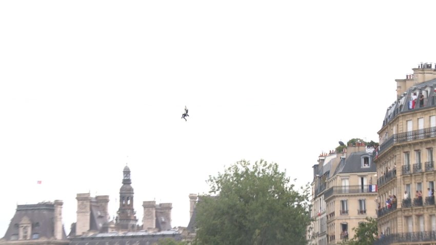 Masked man ziplines over Paris