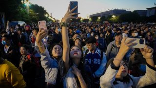 People take smartphone photos of the crowd on a street near Tiananmen Square as visitors gather to watch a flag-raising ceremony on the National Day in Beijing, Sunday, Oct. 1, 2023.