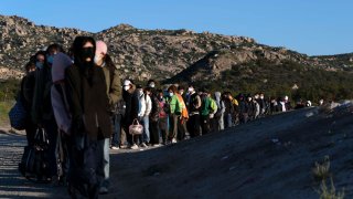 FILE - Chinese migrants wait to be processed after crossing the border with Mexico on May 8, 2024, near Jacumba Hot Springs, Calif. Arrests for illegally crossing the border from Mexico plunged 29% in June to the lowest month of Joe Biden's presidency, according to figures released Monday, July 15, 2024, that provide another window on the impact of a new rule to temporarily suspend asylum.