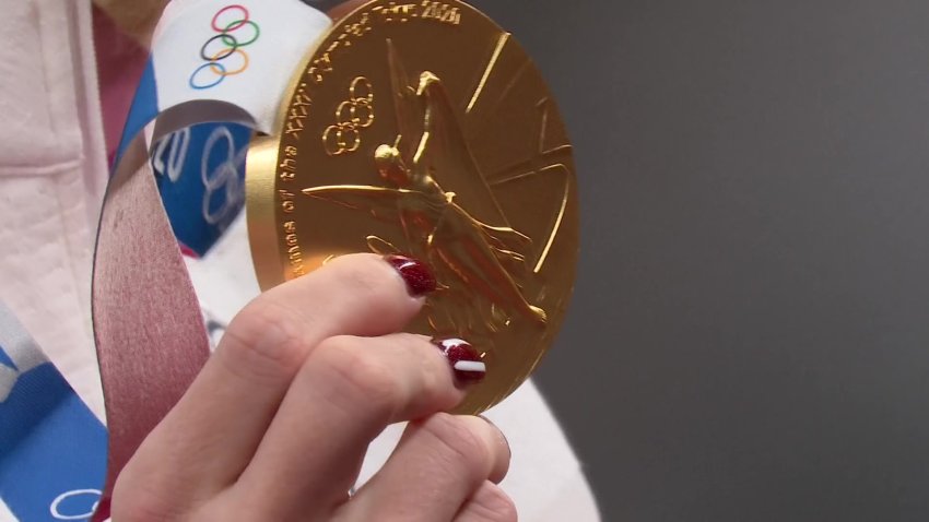 Close-up shot of an Olympian holding a gold medal