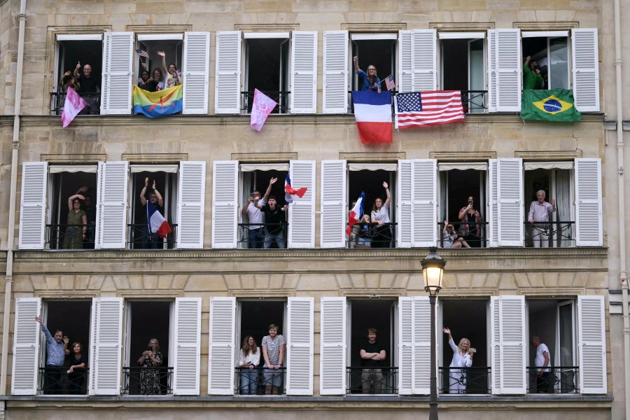 Spectators with various international flags cheer from balconies