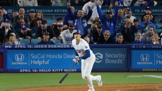 Dodgers designated hitter Shohei Ohtani, #17, watches his ball soar after hitting his first home run as a Dodger off of Giants pitcher Taylor Rogers, # 33, in the seventh inning at Dodger Stadium in Los Angeles Wednesday, April 3, 2024.