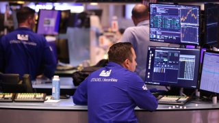 Traders work on the floor of the New York Stock Exchange during afternoon trading on July 26, 2024.