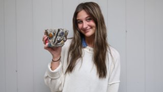 Sophie Hinn with a pencil holder her mom made out of trash.